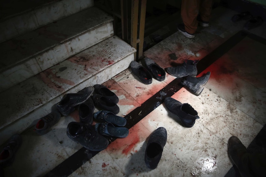 Blood stains and shoes are pictured on stairs inside a Sikh house of worship.