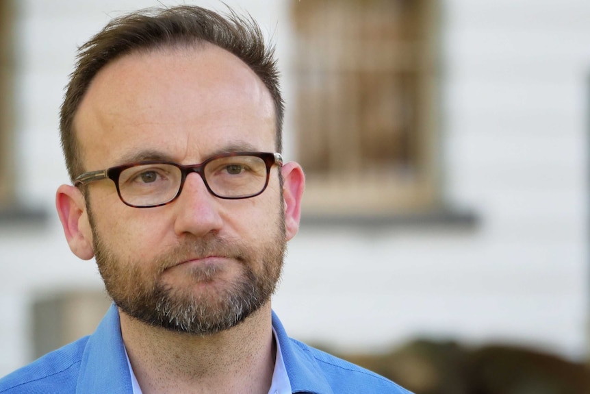 Adam Bandt stands outside at Treasury Place.