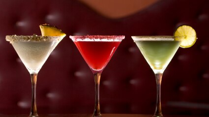 Three different cocktails on a bar table top.