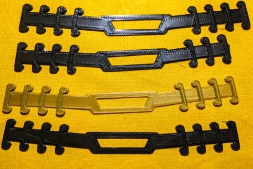 Three black face mask extenders and one gold face mask extender on a yellow background.