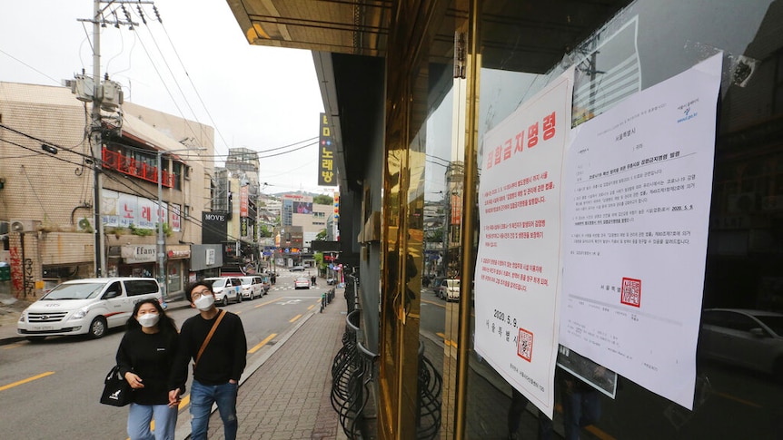 A notice on a closed dance club in Seoul says gatherings are prohibited.