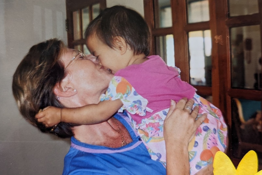 Julie Dowse holding a child who was affected by AIDS in Thailand