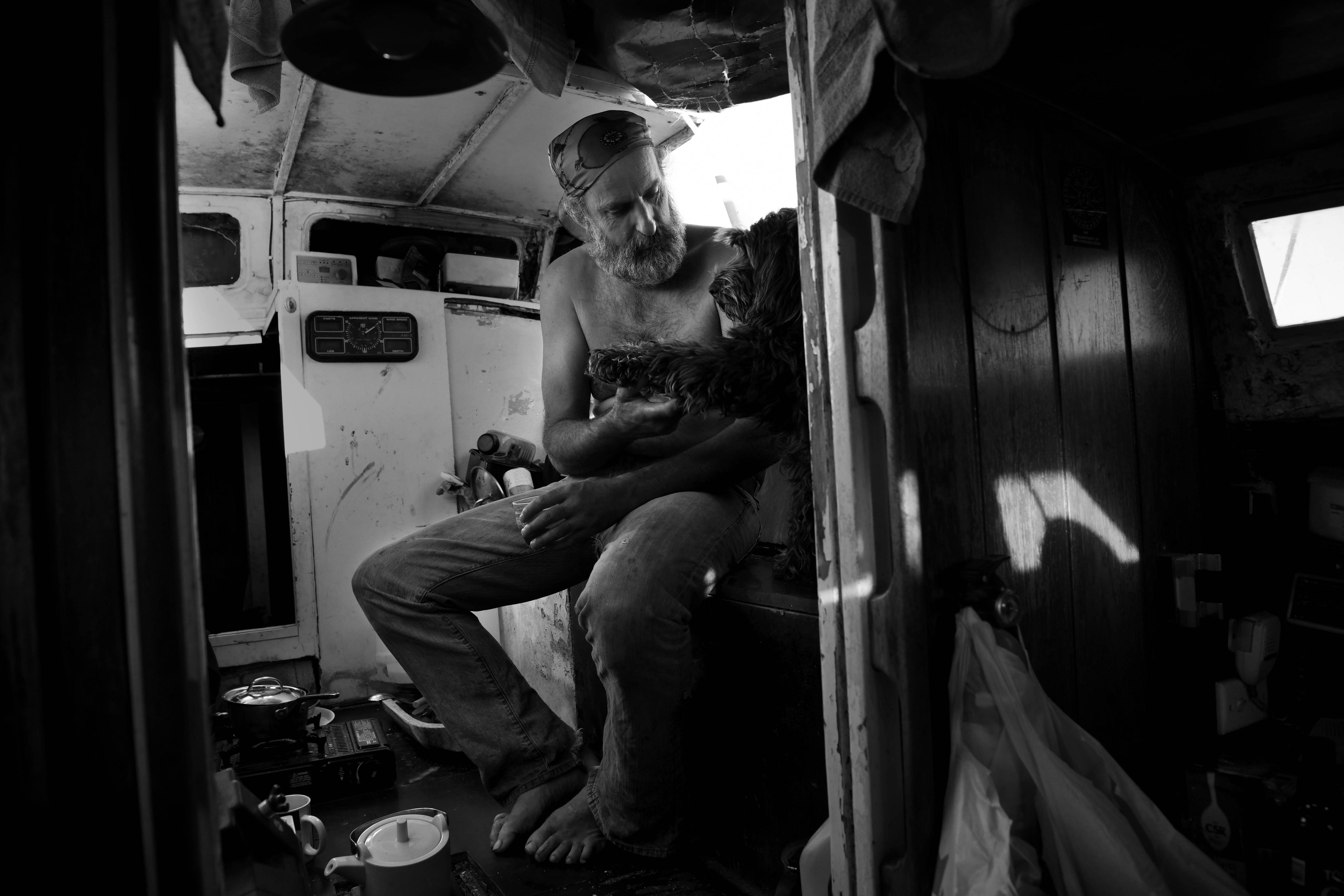 A man looks at a dog as it shakes its paw
