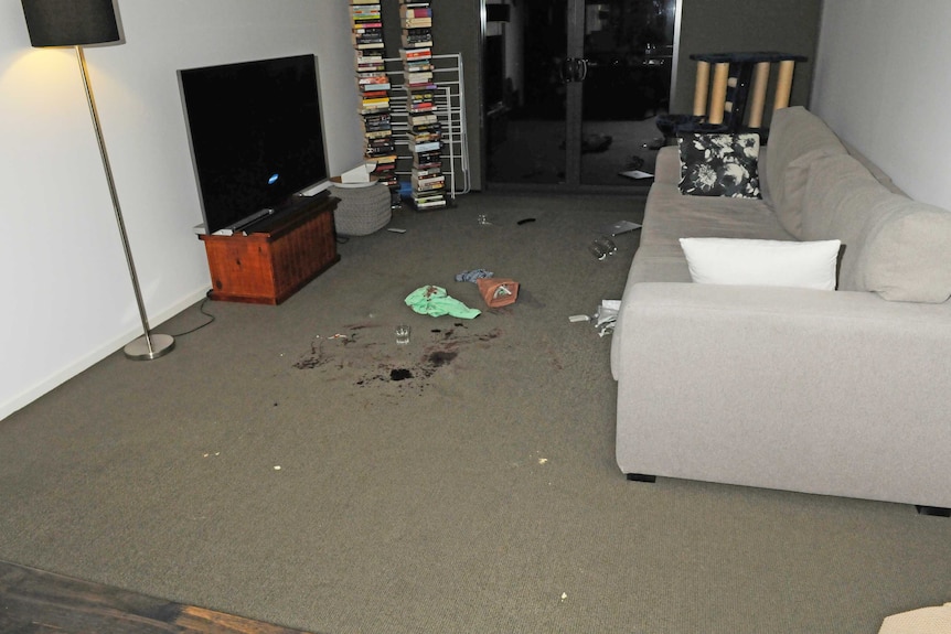 A bloody carpet is seen after an attack in an apartment.