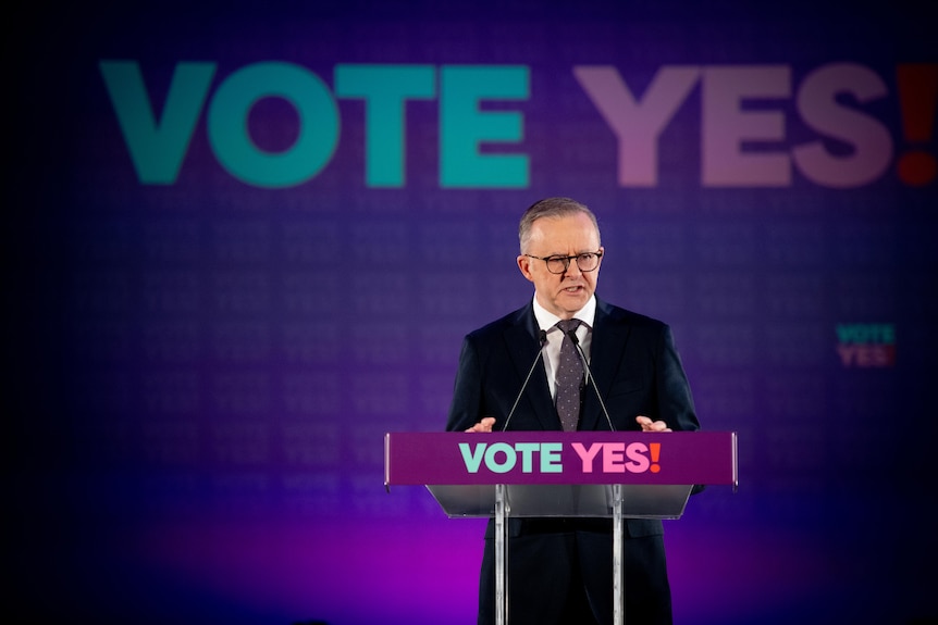 Anthony Albanese standing in front of "VOTE YES" branding as he announces the date of the Voice to Parliament referendum