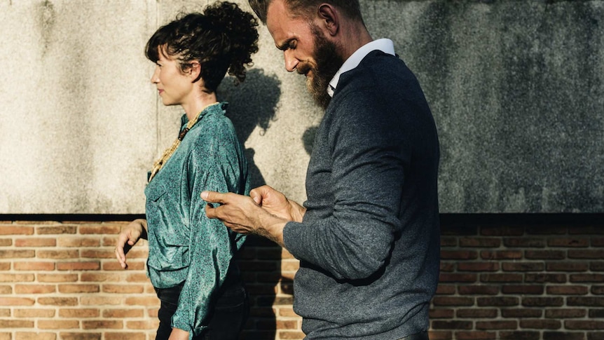 A man and woman walk side by side.