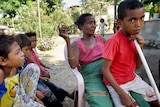 An East Timorese mother poses with her children in Dili