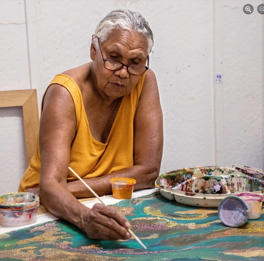 A woman painting at a table