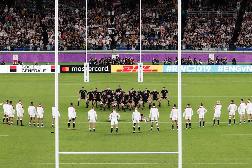 England rugby union players stand in a V shape as they watch the All Blacks perform the haka at the Rugby World Cup.