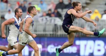 Nat Fyfe kicking a football.