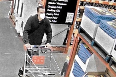 Justin Laurens Stein wearing a mask, shopping in Bunnings with a trolley filled with sand