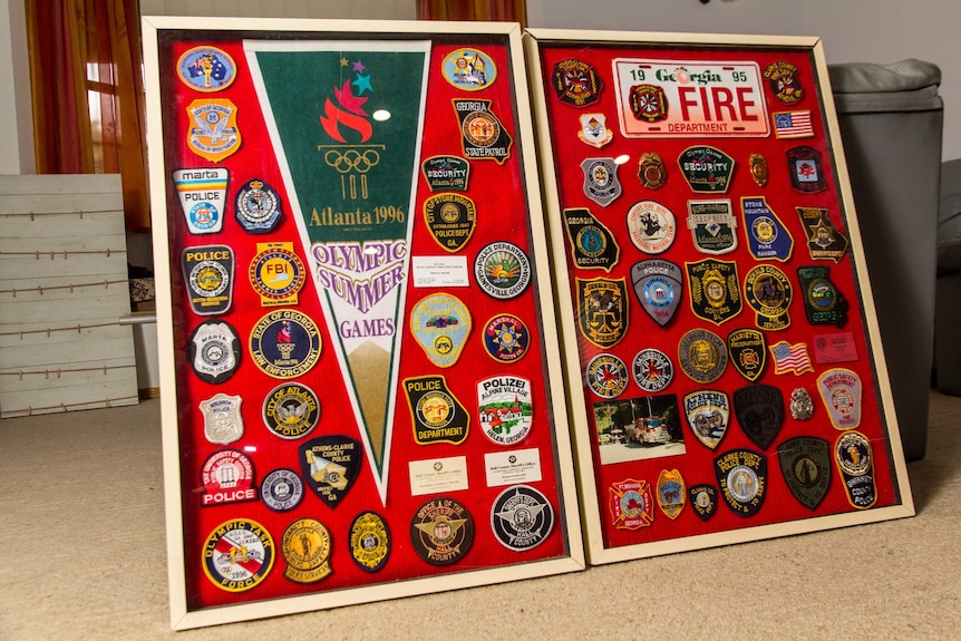 Two pin boards lean against a lounge covered in badges and patches.