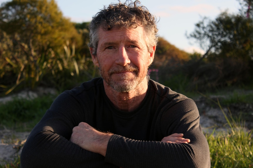 A man with the sun on him, face toward the camera.