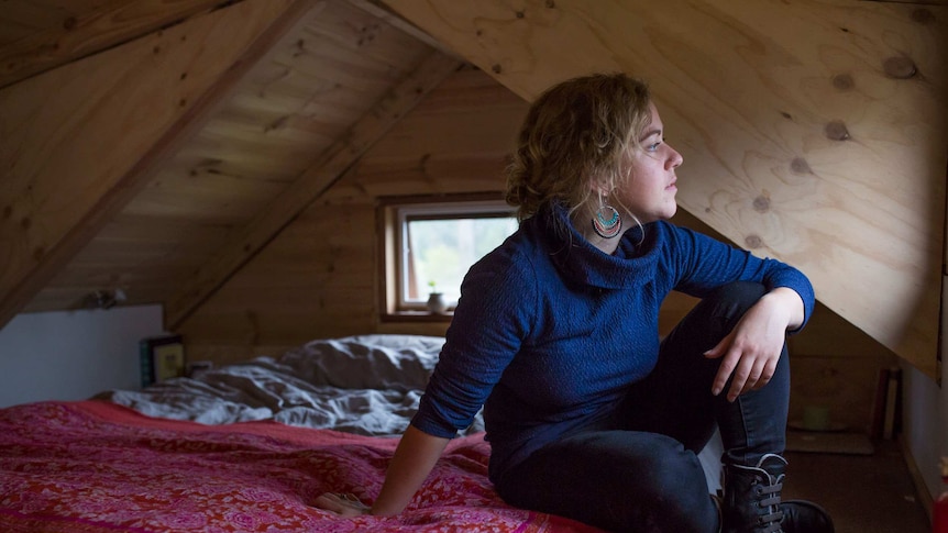 Sarah Smethurst sits on her bed in the loft of her home.