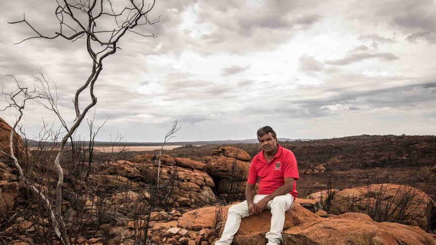 Aboriginal man on his traditional lands after a bushfire