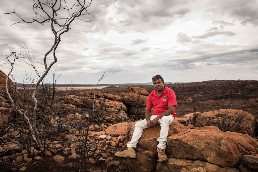 Aboriginal man on his traditional lands after a bushfire