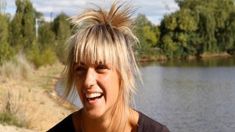 Teenager girl smiles beside lake