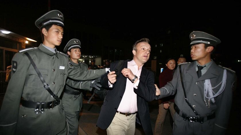 Chinese security guards push a foreign journalist
