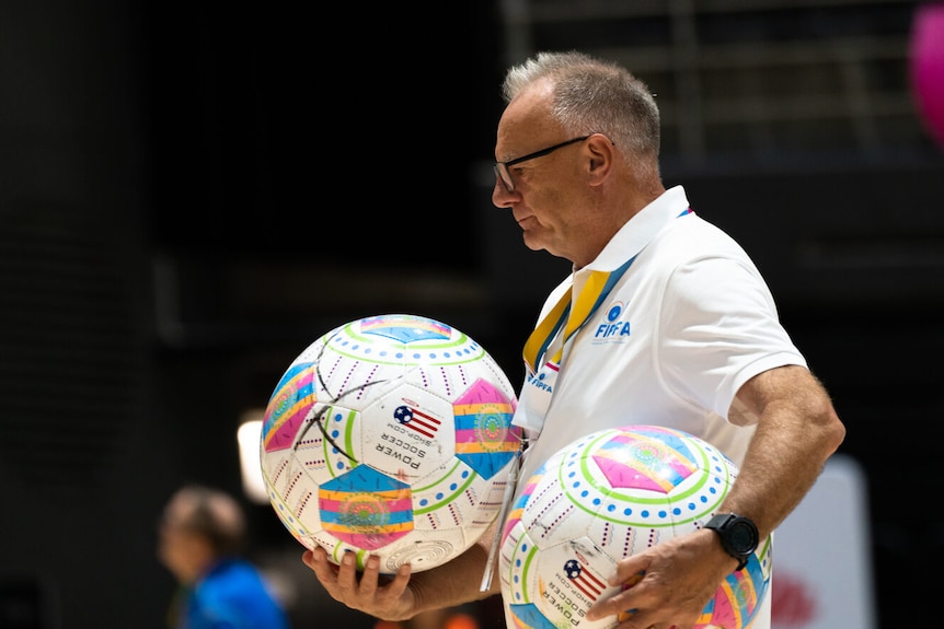 a referee holding onto two footballs at th powerchair football world cup in sydney