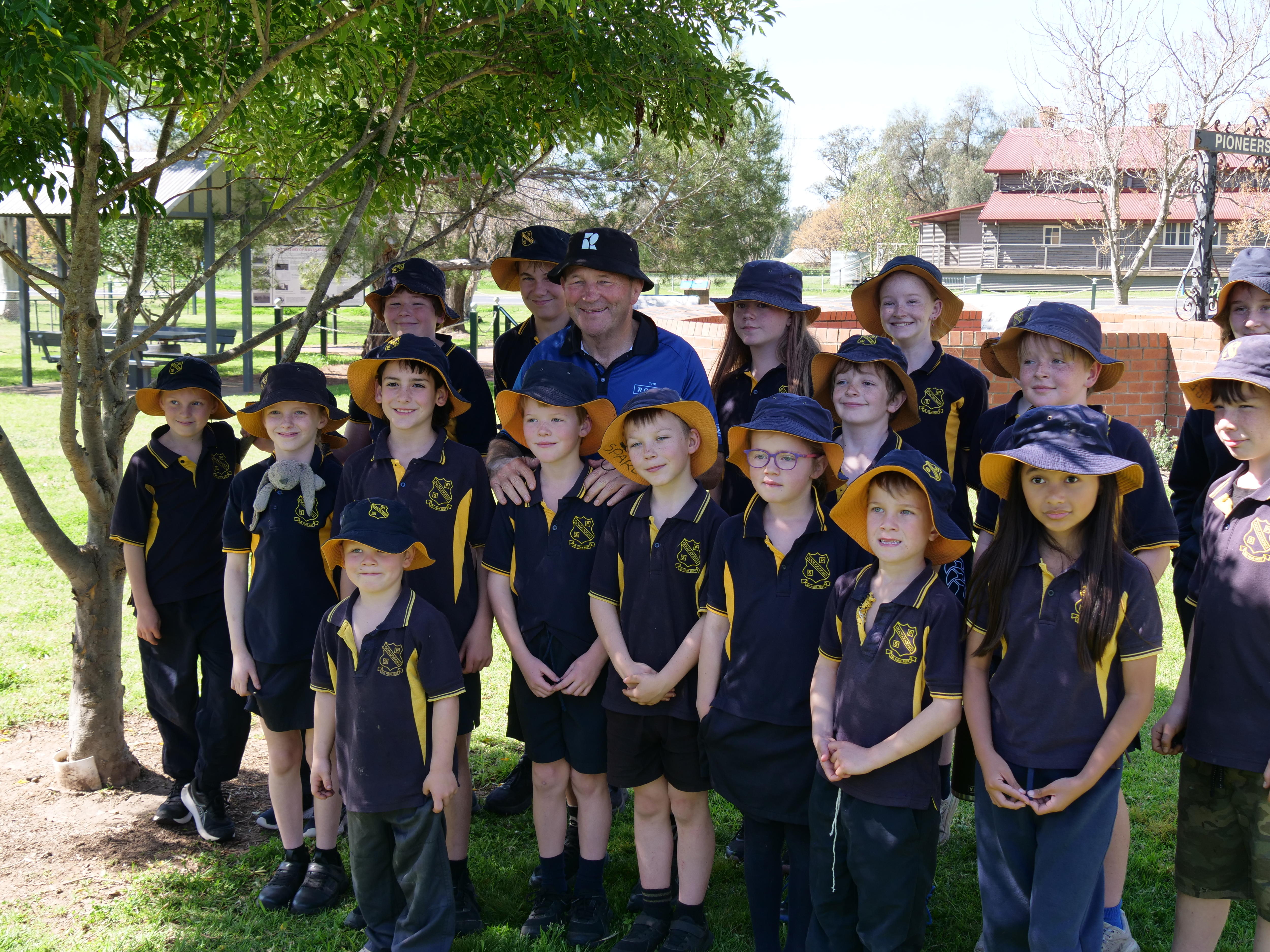 A man standing with a dozen children