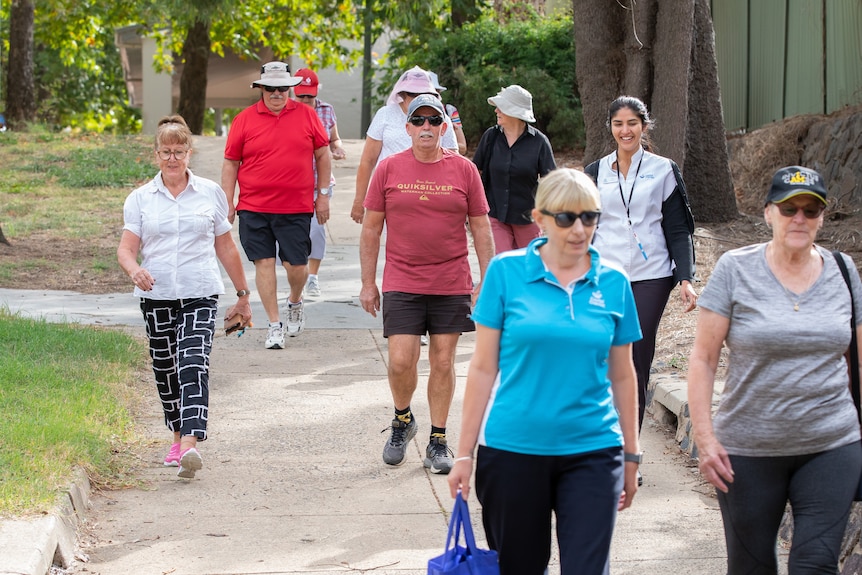 A group of people walk along a footpath