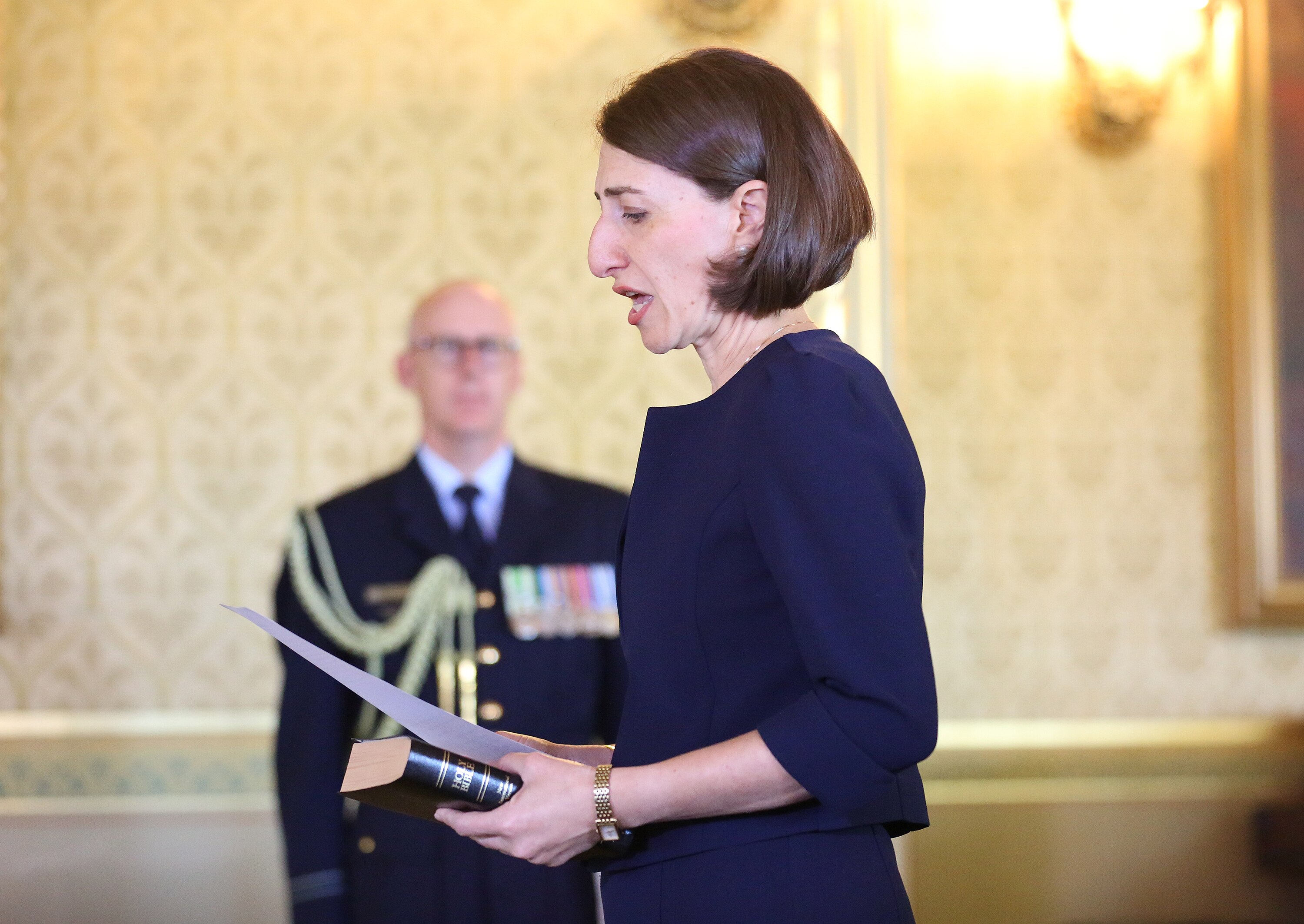 a woman reading out loud from a piece of paper