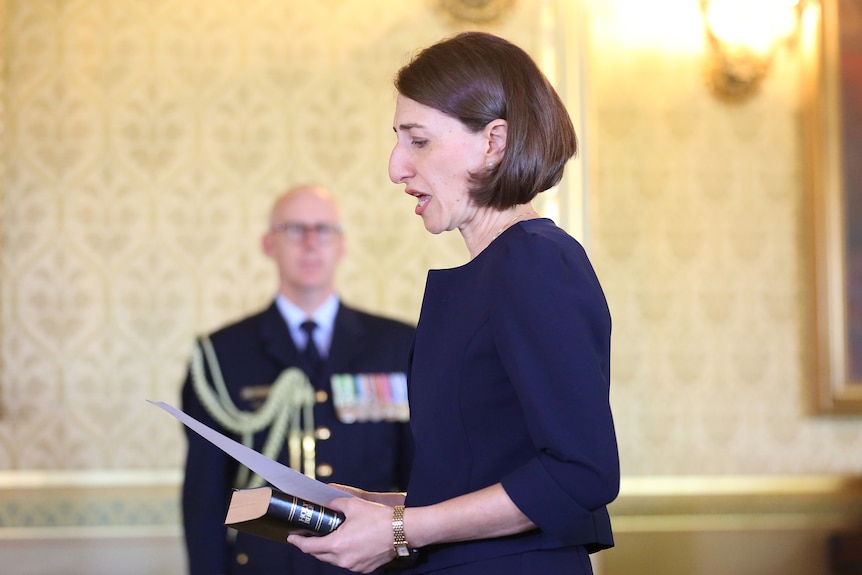 a woman reading out loud from a piece of paper