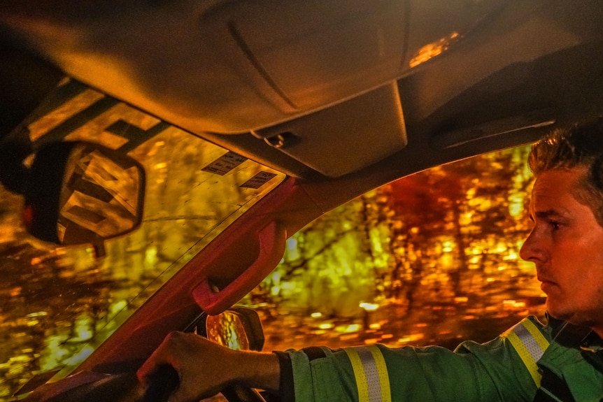 A firefighter in a car entering the firefront