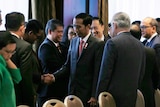 Indonesian President Joko Widodo greets delegates
