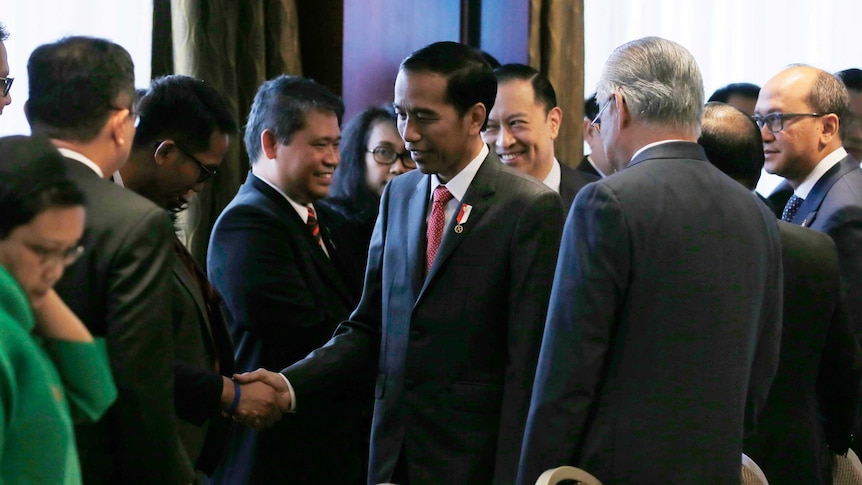 Indonesian President Joko Widodo greets delegates