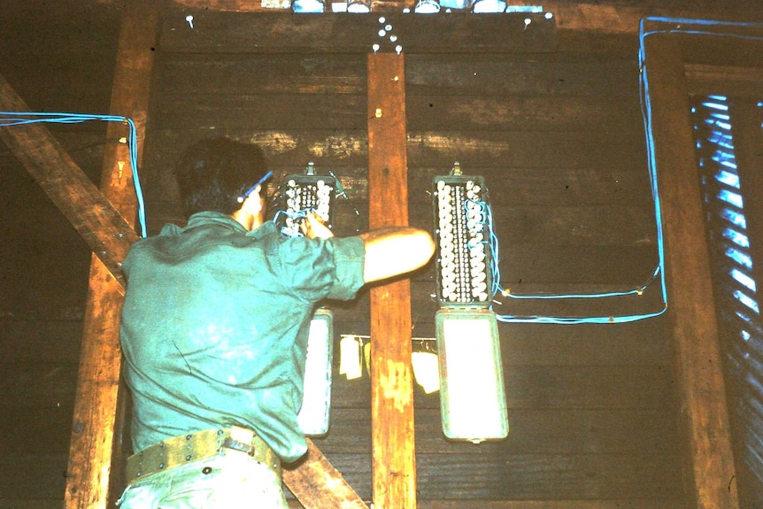 Tom Case wiring up telephone and radio systems inside a communications bunker.