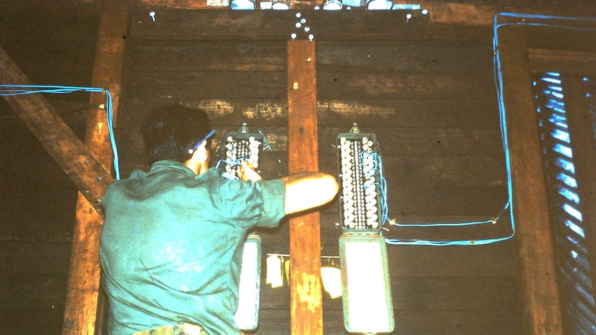 Tom Case wiring up telephone and radio systems inside a communications bunker.