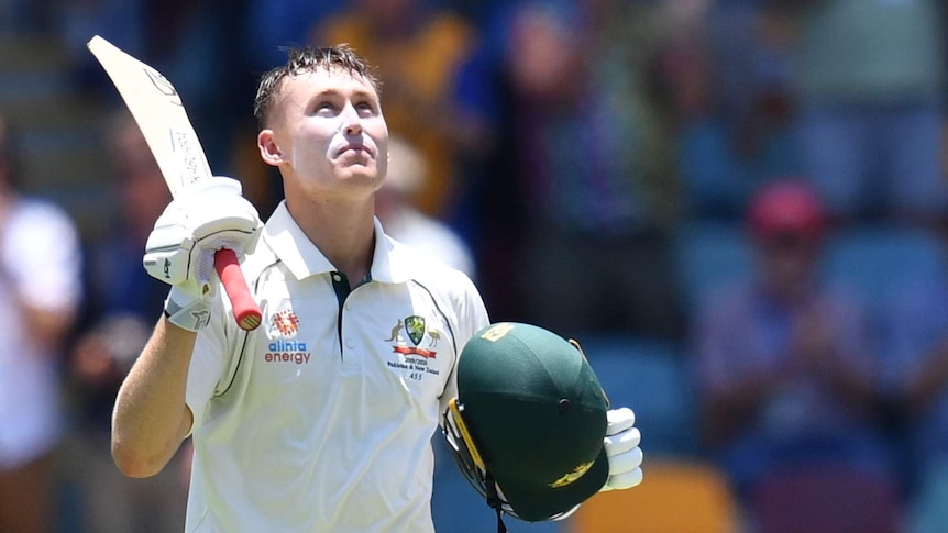Australia batsman Marnus Labuschagne looks up into the sun and raises his bat during a Test.