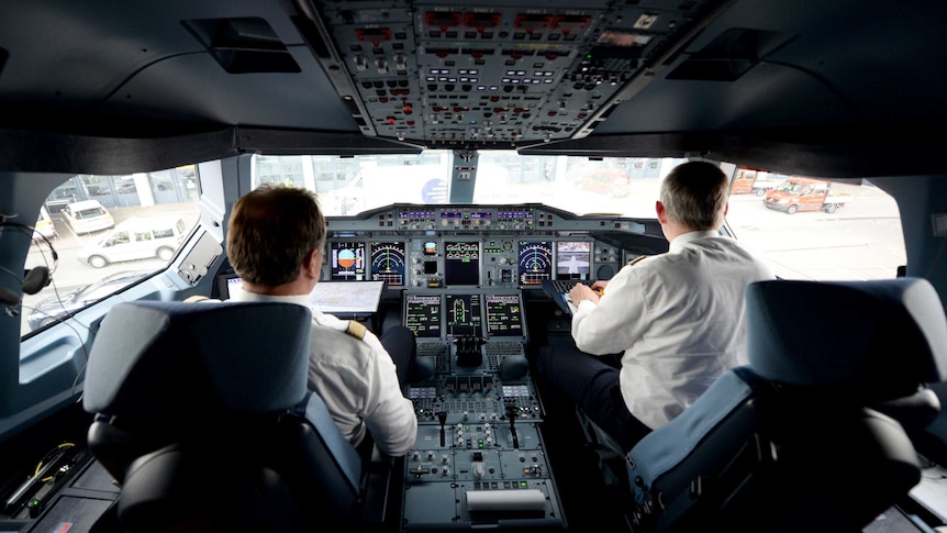 Two pilots in a cockpit of an airbus A380 plane
