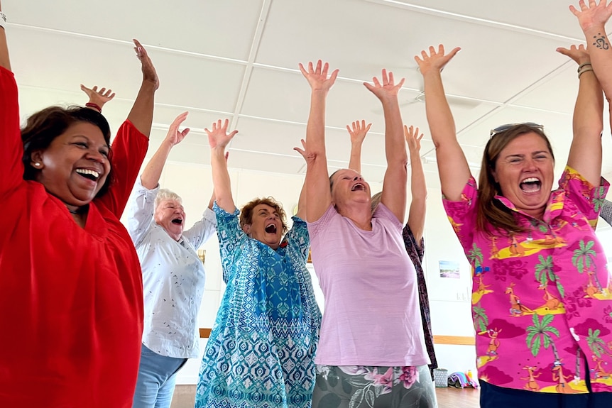 Women smile and laugh with arms in the air