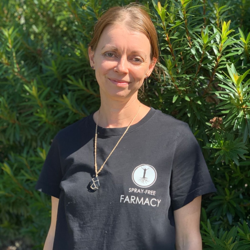 Kristen Ottaway wears a black t-shirt and crystal necklace, smiling at the camera.