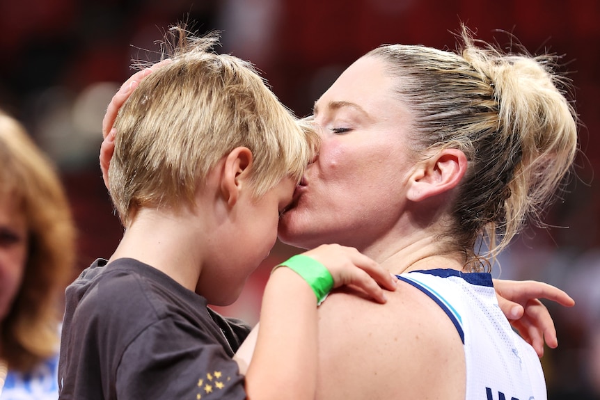 Southside Flyers WNBL player Lauren Jackson kisses her son on the forehead.