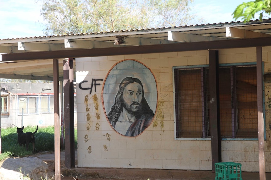 A painting of Jesus on the wall of a derelict town camp church