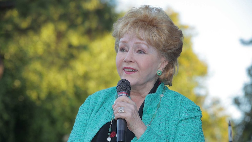 Debbie Reynolds with a microphone