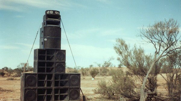 Black PA speakers stacked on top of each other in a pyramid.