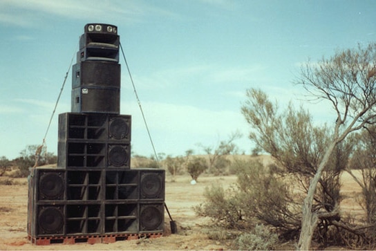 Black PA speakers stacked on top of each other in a pyramid.