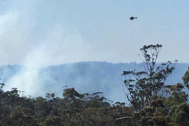 A water bombing helicopter over a fire near Orford on Tasmania's east coast.