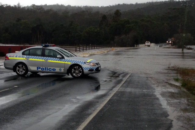 Police close off a road as flood waters rise in Rocherlea in northern Tasmania