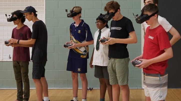Teenagers wear VR headgear to race drones