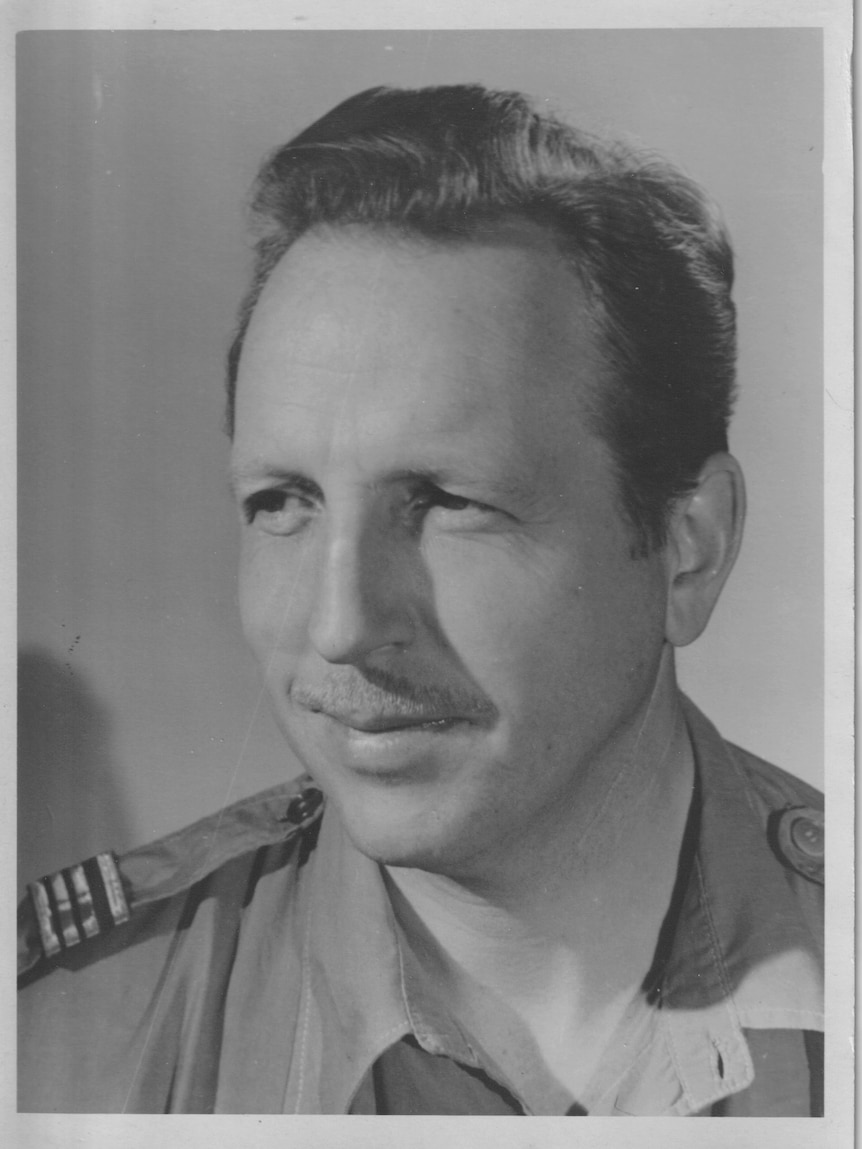 A black and white portrait of a man in his forties with a mustache and brown hair. 
