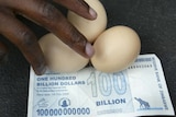 A vendor arranges eggs on a 100 billion Zimbabwean dollar note