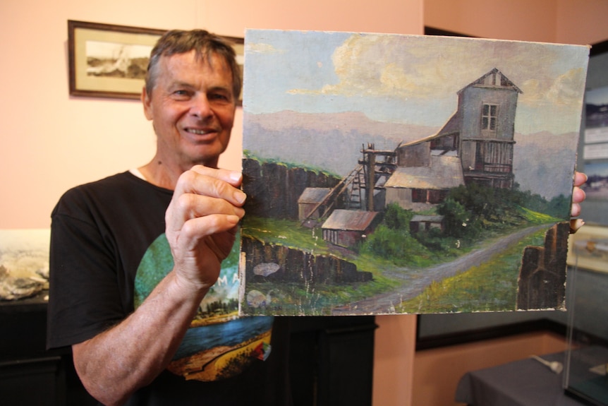 Mr Bedford holds a picture depicting a rock crusher building.
