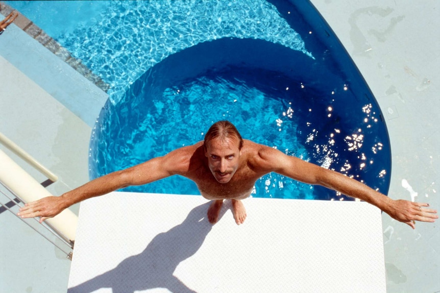 A man preparing to dive into a pool