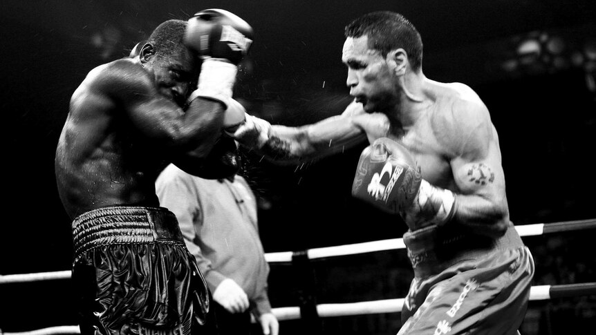 Black and white photo of a boxing fight, featuring Anthony Mundine.