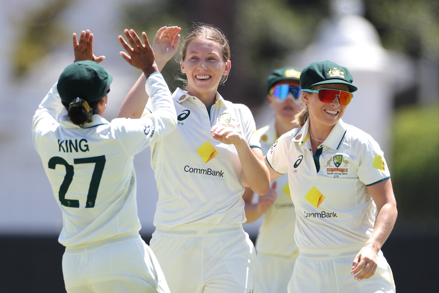 Darcie Brown is congratulated by Australia Test teammates Alana King and Sophie Molineux after a wicket against Australia.